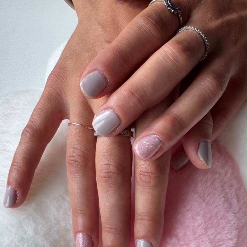 Graue Nägel mit rosa Glitzer-Akzent